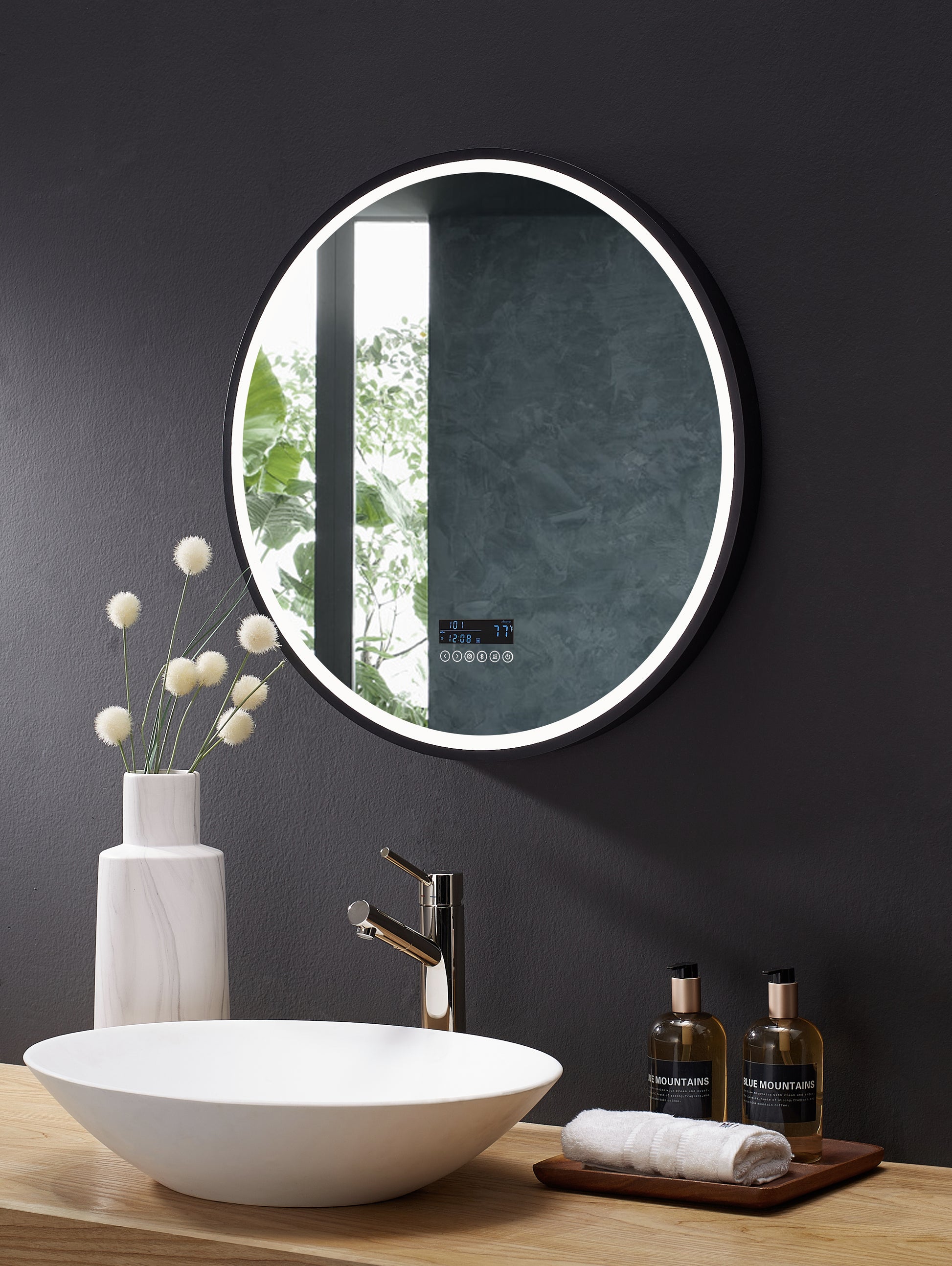 Image shows angled view of round mirror over bathroom vanity.  Edge of mirror is illuminated by LED.