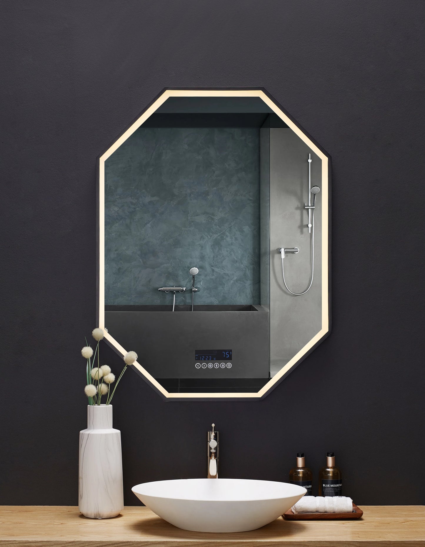 Image is photo of eight sided mirror—taller than wide, above a bathroom vanity.