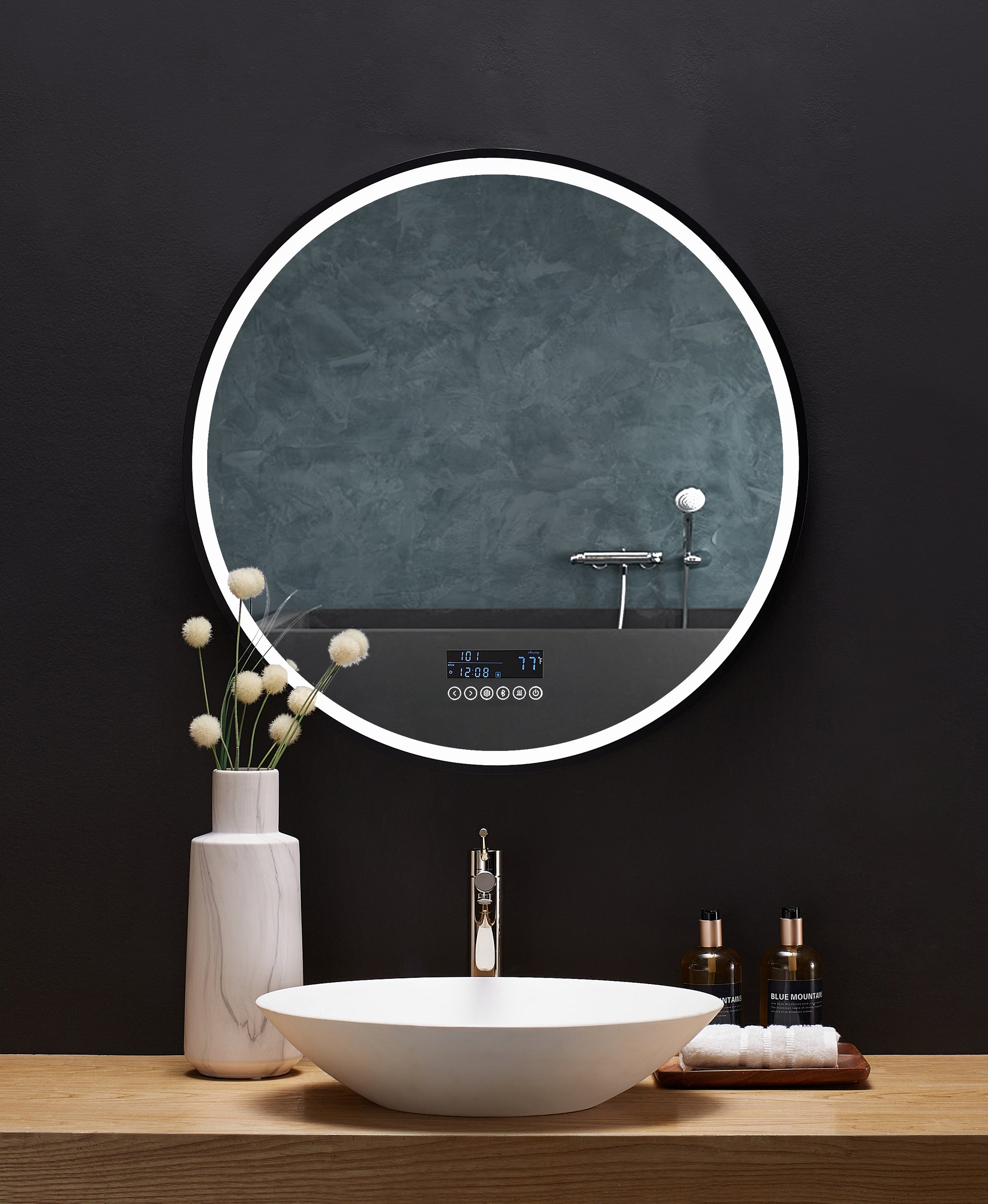 Image shows round mirror above bathroom vanity.  LED light is illuminated around edge of mirror.